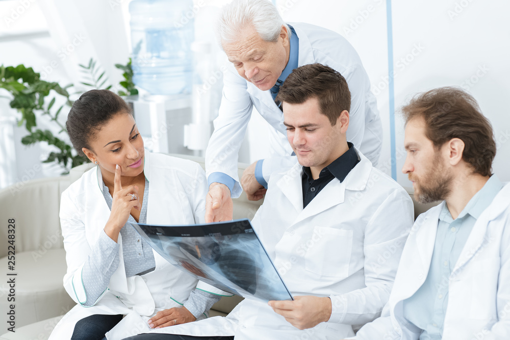 Group of diverse doctors discussing x-ray of the patient Group of diverse doctors discussing x-ray of the patient