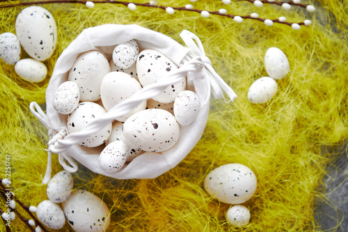 Easter white dotted Eggs in the nest and spring yellow grass