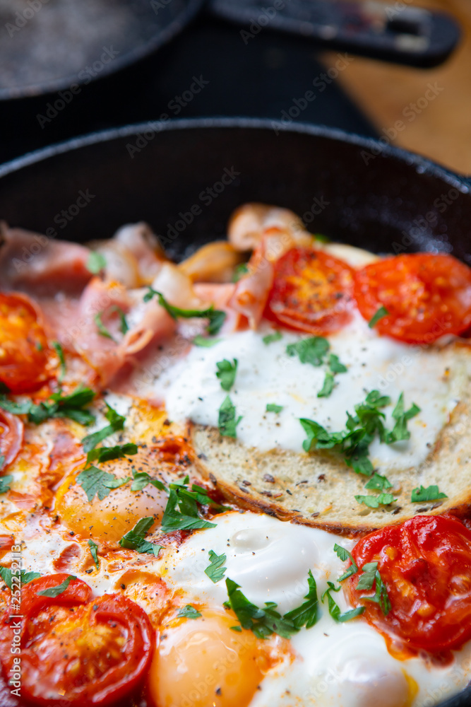 Fried eggs with bacon, toast and tomatoes in a pan Fried eggs with bacon, toast and tomatoes in a pan