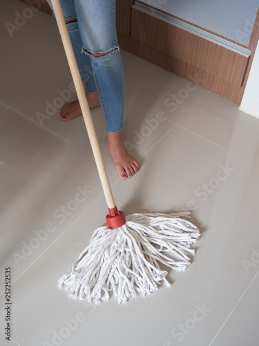 She is moping the floor in her house