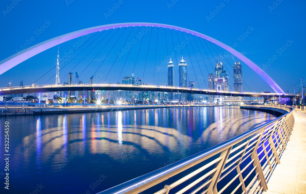 Obraz premium colorful sunset over Dubai Downtown skyscrapers and the newly built Tolerance bridge as viewed from the Dubai water canal