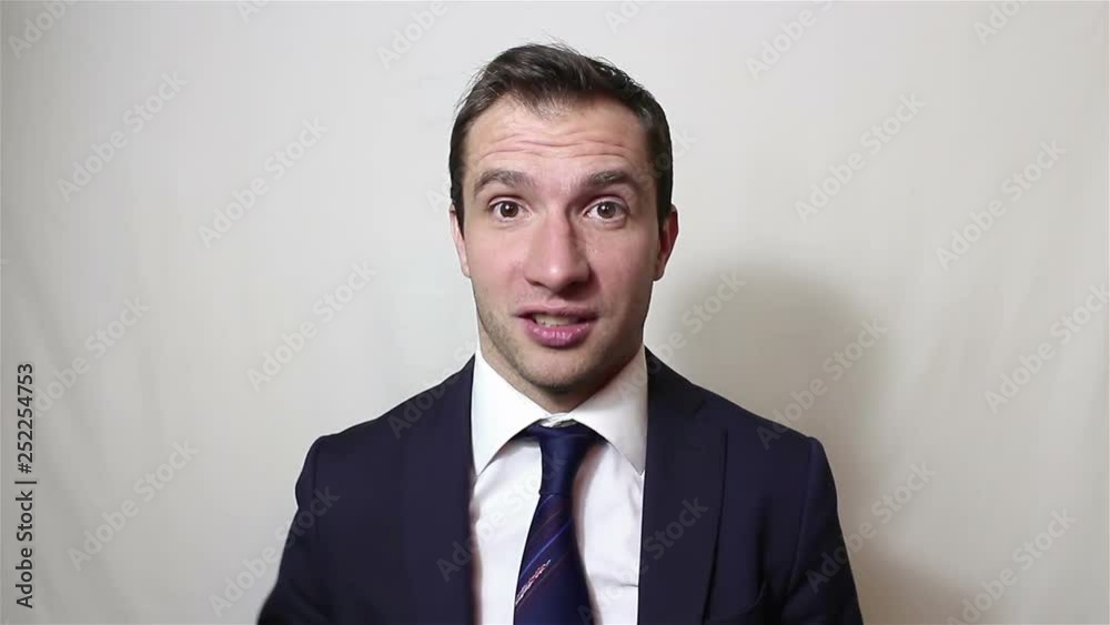 Young handsome businessman is looking at the camera and actively swearing.Portrait on a white background.