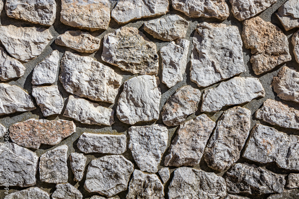 Wall made of cement and irregularly shaped stones. Architectural detail, closeup. Texture, material background. Wall made of cement and irregularly shaped stones. Architectural detail, closeup. Texture, material background.