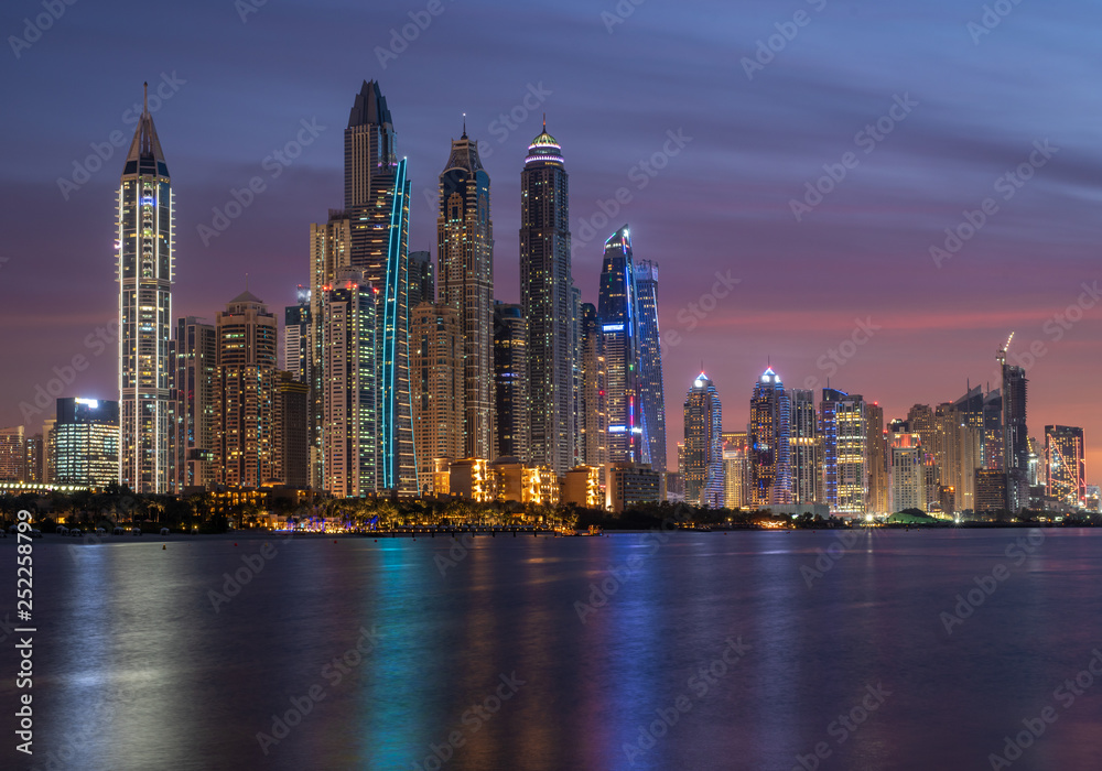 Dubai Marina skyscrapers in the illuminations and their reflection in the water