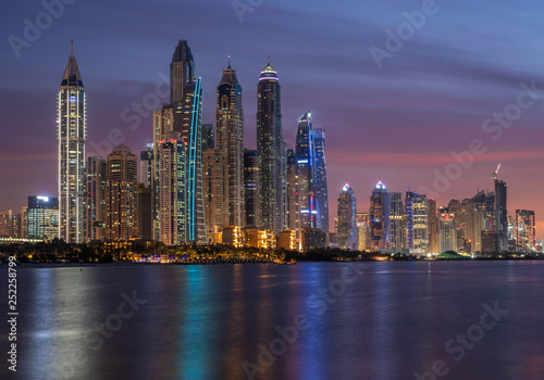 Dubai Marina skyscrapers in the illuminations and their reflection in the water