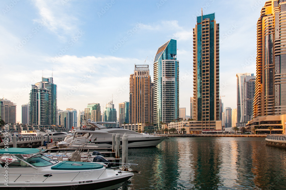 Obraz premium DUBAI, UAE - FEBRUARY 2018: View of modern skyscrapers shining in sunrise lights in Dubai Marina in Dubai, UAE
