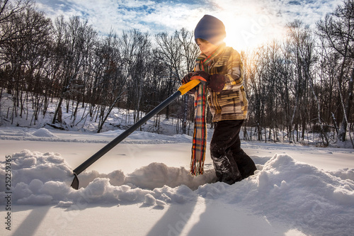 Canvas Print Young boy shoveling lots of snow