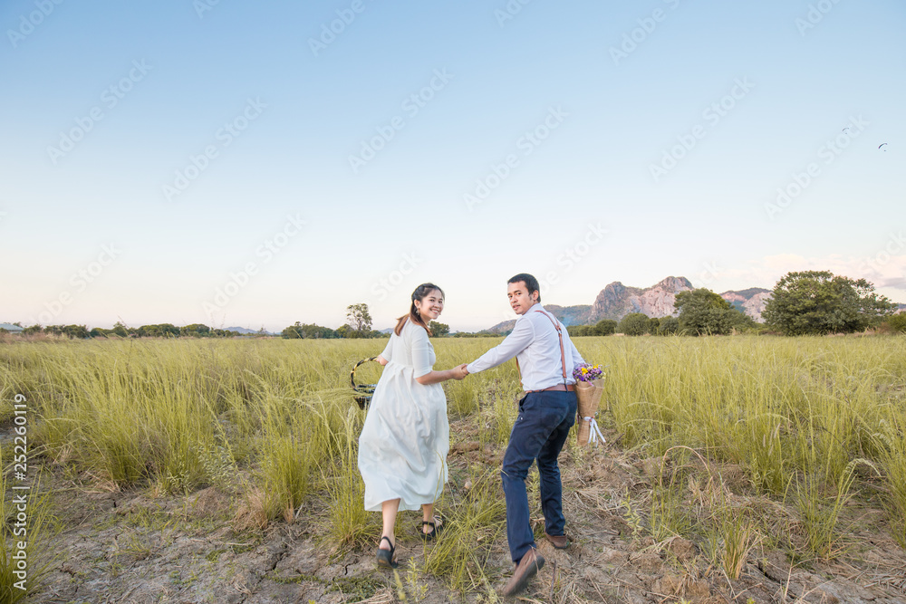 Couple of love running together in green field
