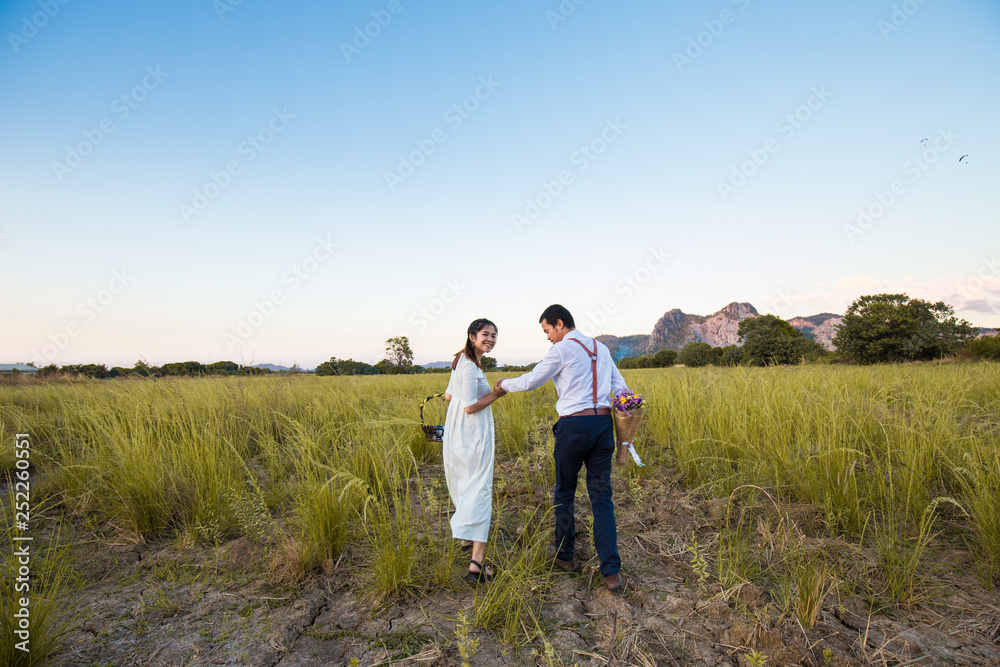 Couple of love running together in green field