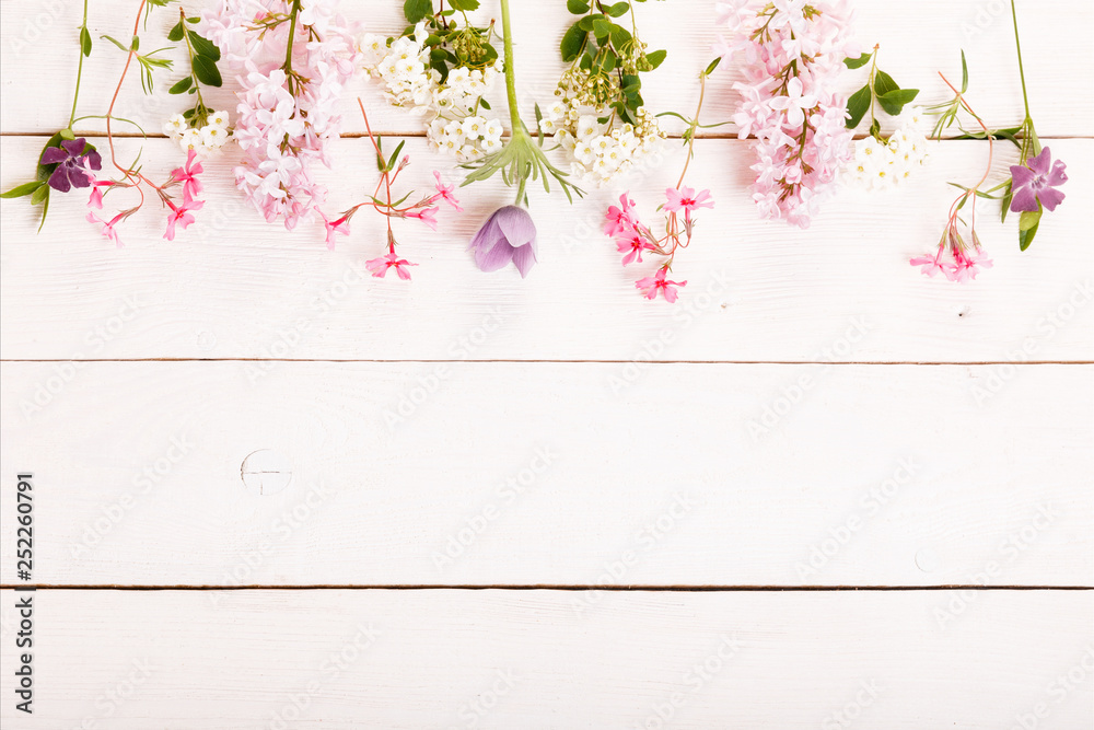 Fototapeta premium Festive flower composition on the white wooden background. Overhead view