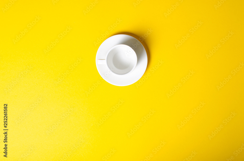 Empty cup with saucer on yellow background, top view Empty cup with saucer on yellow background, top view