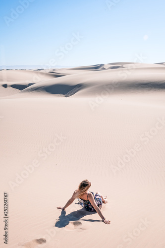 Women sitting in the Desert / Dune looking out in the scene