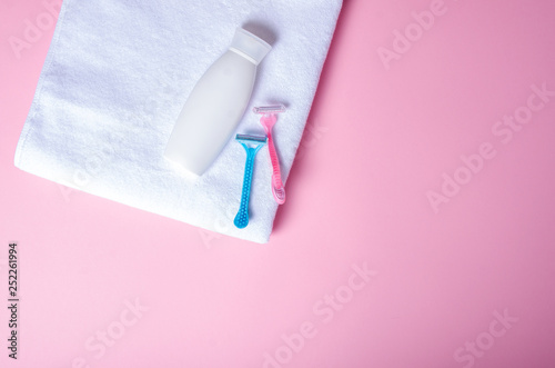 White towel, bottle cream, lotion, razor, soft beauty on pink background, top view