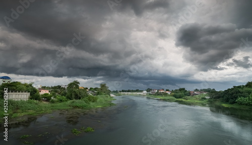 river view of dark clouds with heavy rain storm above Mae Klong river in Ban Pong District, Ratchaburi Province, west of Thailand.