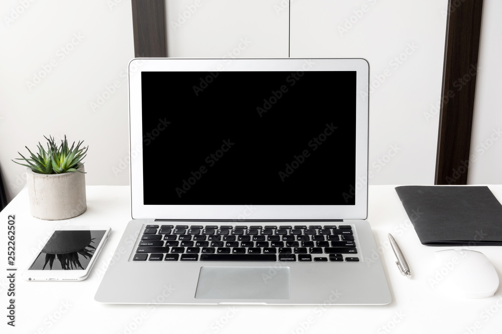 Laptop computer and smartphone with blank mock up screens are on top of white office desk table. Laptop computer and smartphone with blank mock up screens are on top of white office desk table.