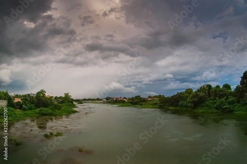 river view of dark clouds with heavy rain storm above Mae Klong river in Ban Pong District  Ratchaburi Province  west of Thailand.
