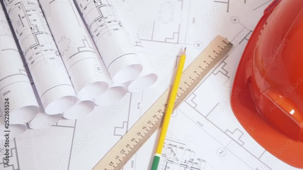 Paper architectural drawings, blueprint and helmet. Engineering blueprint