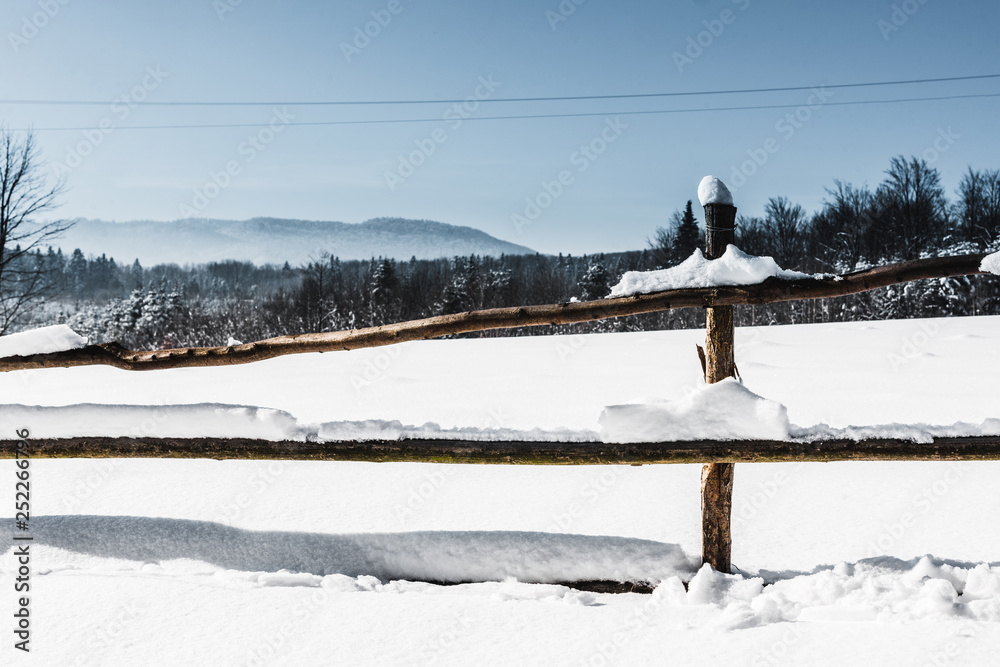 Fototapeta premium wooden fence covered with snow in carpathian mountains