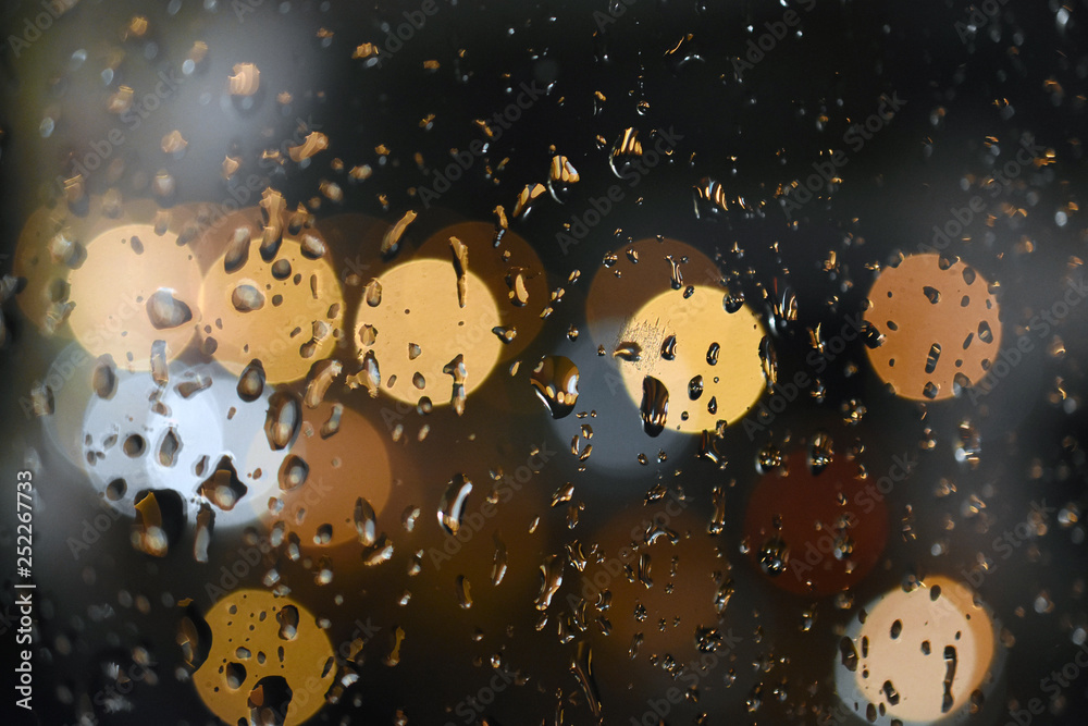 Krople deszczu na okiennej szybie, z kolorowymi światłami samochodów w tle. Miejski widok z okna, abstrakcja, deszczowa noc, bokeh - obrazy, fototapety, plakaty 