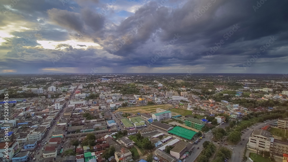 Aerial view above city of dark clouds moving with rain storm background, Ban Pong City, Ratchaburi, Thailand.