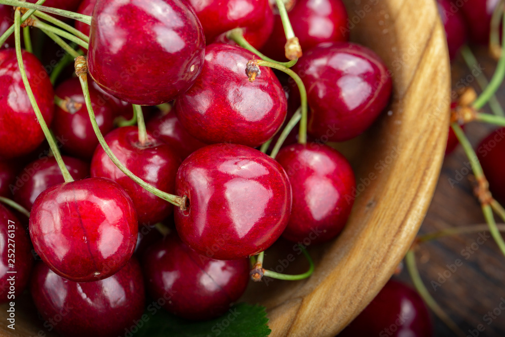 Wooden plate with ripe juicy cherries on table. Wooden plate with ripe juicy cherries on table.