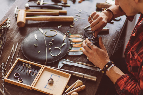 man cleaning the jewellery for client, close up cropped photo