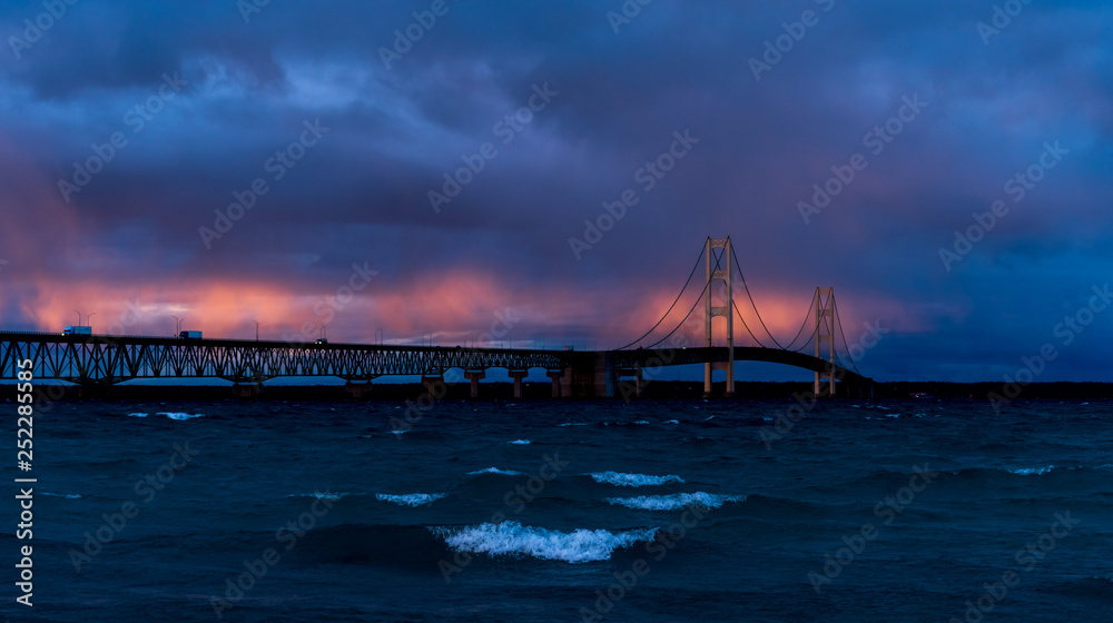 Obraz premium Mackinac Bridge spanning the Straits of Mackinac between the upper and lower peninsulas of Michigan, USA at sunset.