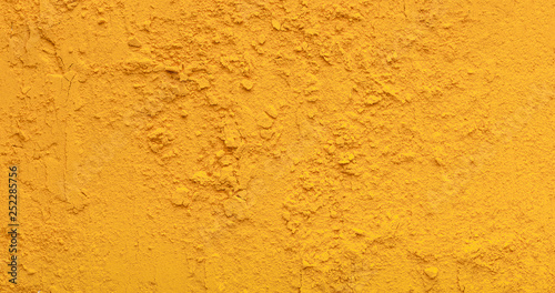 Yellow tirmeric powder texture, natural condiment background photo