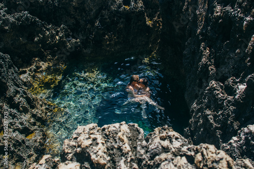 Man and woman together swimming and kissing in the pool