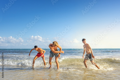 Group of young men playing at the beach
