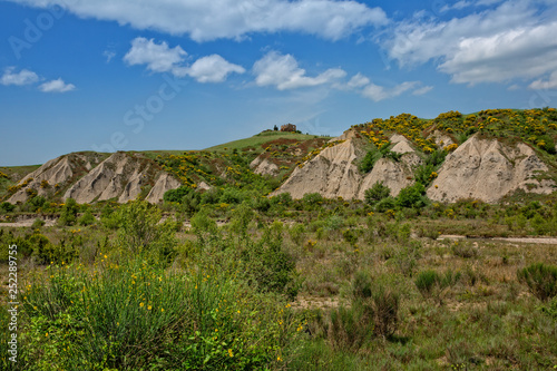 View of the Crete Senesi country landscape with an old ruin.Crete Senesi landscape erosion forms of Calanchi near Siena, Tuscany, Italy