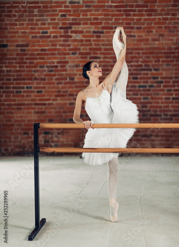 propper ballet technique.full length photo. attractive girl shows developpe, dancer reached the air photo