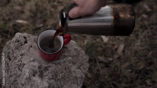 Red and Blue cups of coffee on the wooden bench. Poured from a coffee pot
