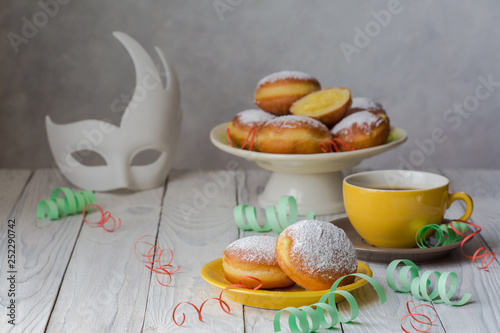 Bombolone - filled sweet yeast dough fried in oil, with a cream. Italian carnival  doughnuts and party decorations. photo