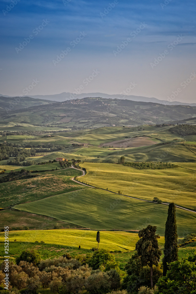 View of valley Val D`Orcia on sunset. Scenic Tuscany landscape panorama in sunset with rolling hills and harvest fields, Val d'Orcia, Tuscany, Italy