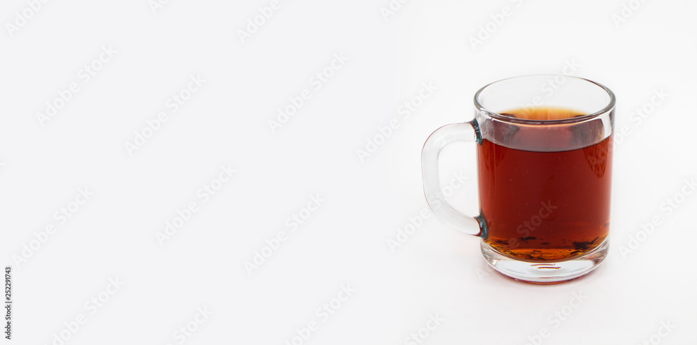 Delicious black tea in a transparent mug on a white background.Horizontal photo Delicious black tea in a transparent mug on a white background.Horizontal photo