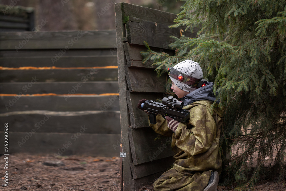 Fototapeta premium Boy with a gun playing lasertag on nature park.