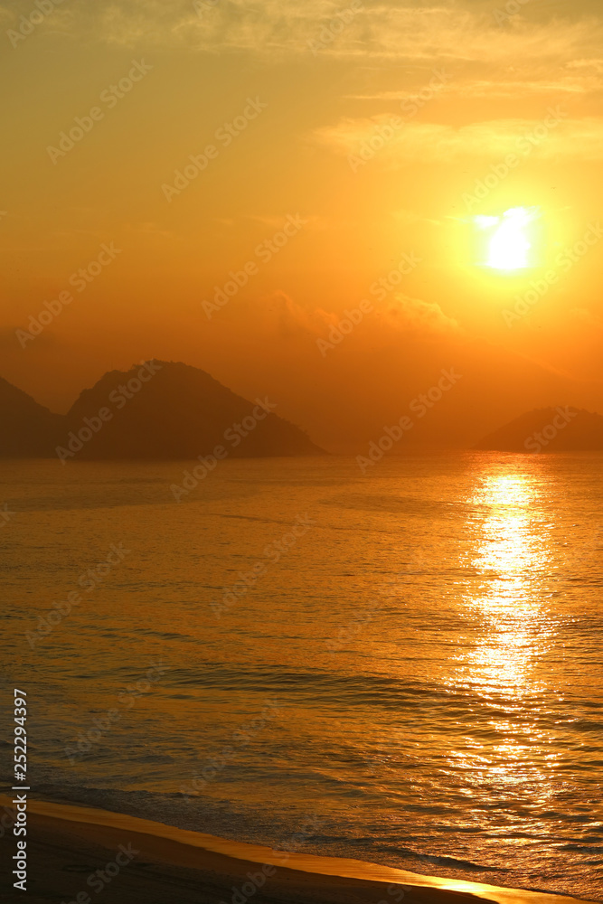 Vertical image of breathtaking sunrise over the Atlantic ocean view from Copacabana beach, Rio de Janeiro, Brazil