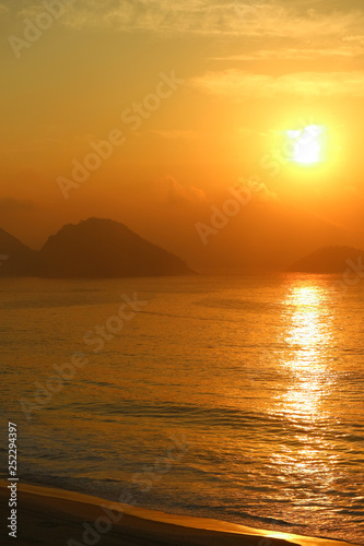 Vertical image of breathtaking sunrise over the Atlantic ocean view from Copacabana beach, Rio de Janeiro, Brazil © jobi_pro