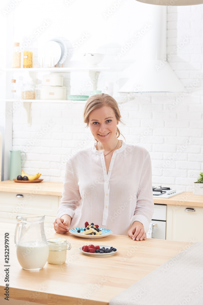 happy young woman preparing tasty snacks at the kitchen table in the morning light happy young woman preparing tasty snacks at the kitchen table in the morning light