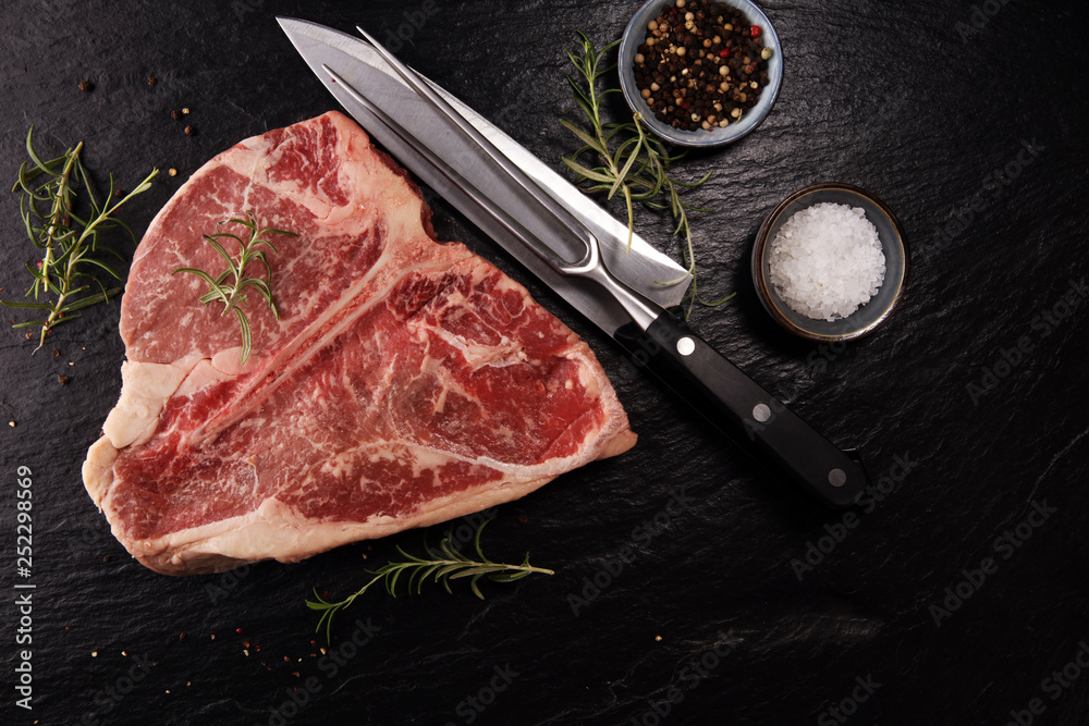 Raw T-bone steak on stone cutting board.
