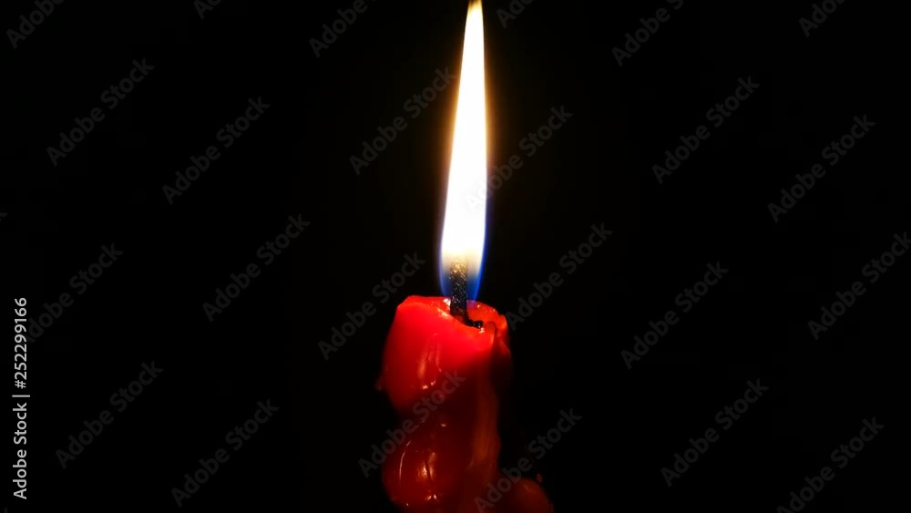 Vela roja encendida sobre fondo negro