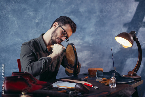 active ambitious shoemaker performing shoes in the craft studio, close up photo photo