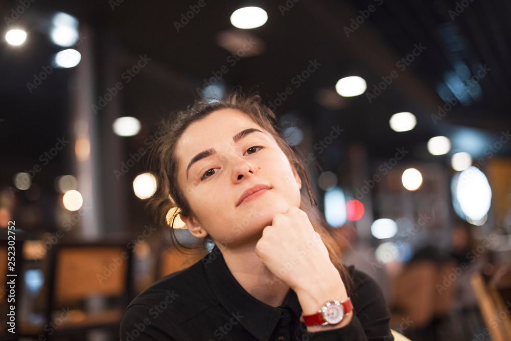 Gorgeous smiling young woman with dark hair eating cake and drinking coffee at a cafeteria in the evening sitting by the window. selective focus, noise effect Gorgeous smiling young woman with dark hair eating cake and drinking coffee at a cafeteria in the evening sitting by the window. selective focus, noise effect