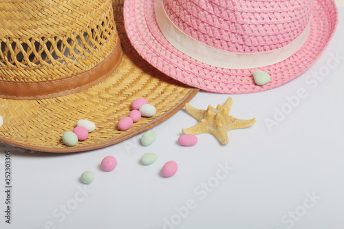 Accessories for summer holidays. Sun hats, colored pebbles and starfish on a white background.