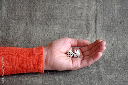 Foto White dices on the male palm, close up. Board games.