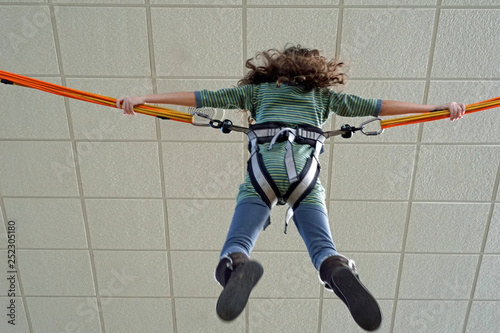 Child playing on indoor bungee ride