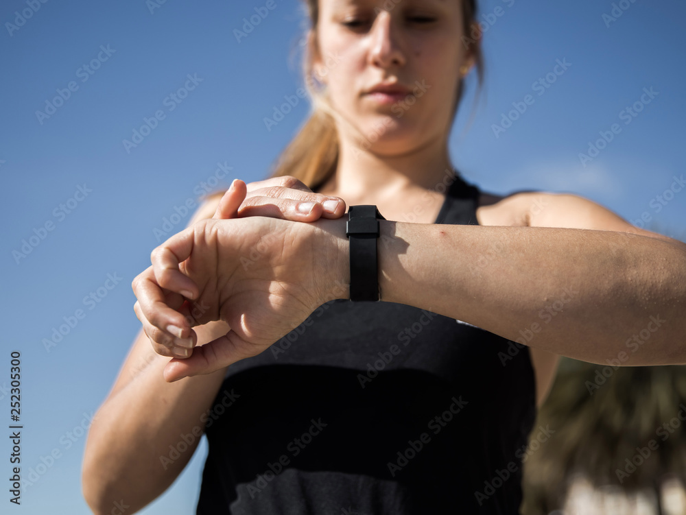 blondie woman wearing sport wear looking her watch