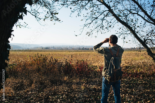 Man in the forest looks through binoculars © pawle