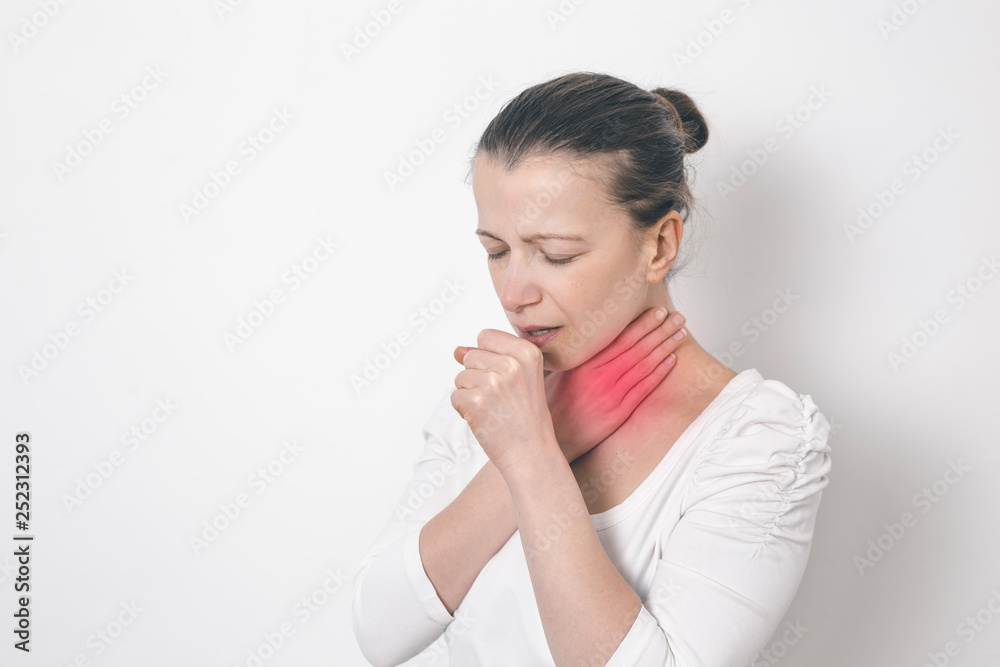 Woman coughing holding on to a sore throat. Woman coughing holding on to a sore throat.